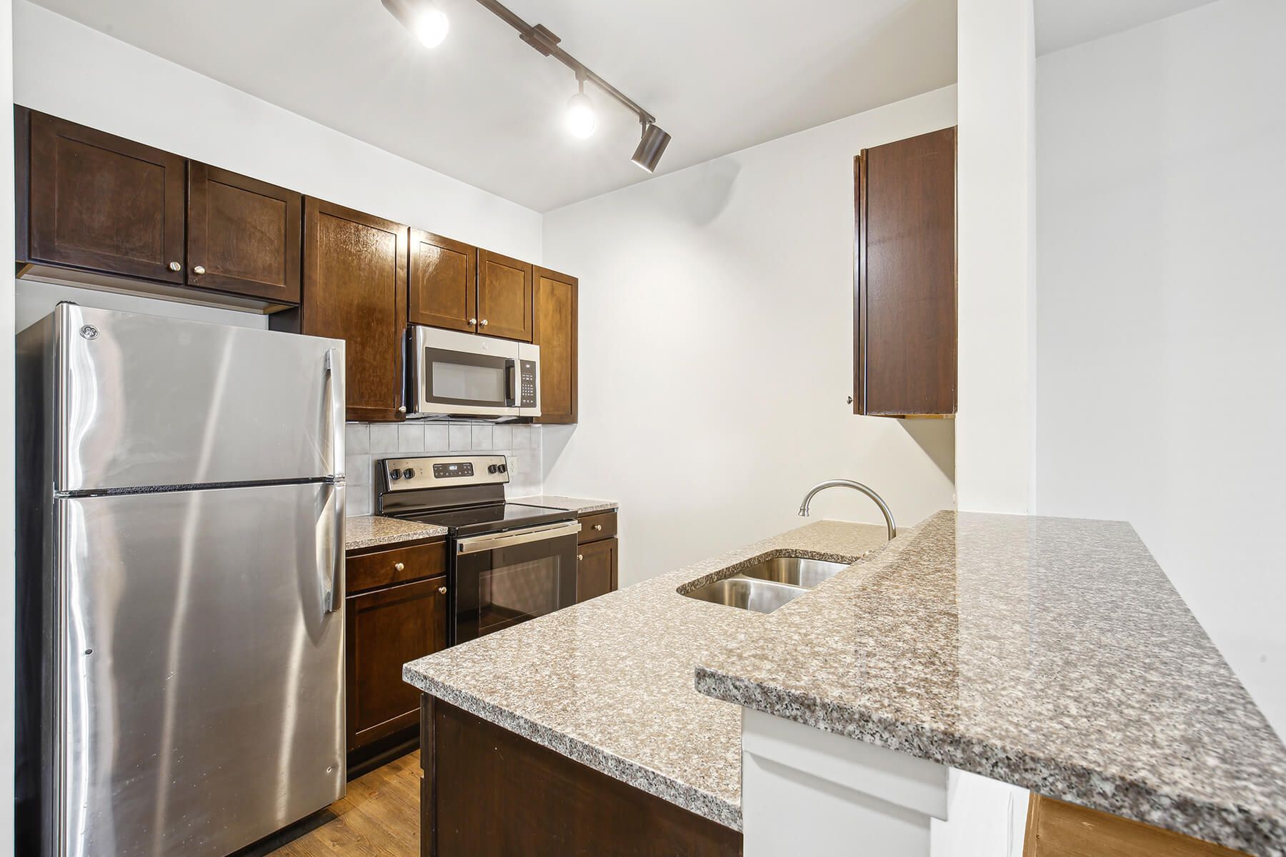 Luxury apartment kitchen with stainless steel appliances, granite countertops, and lots of storage space